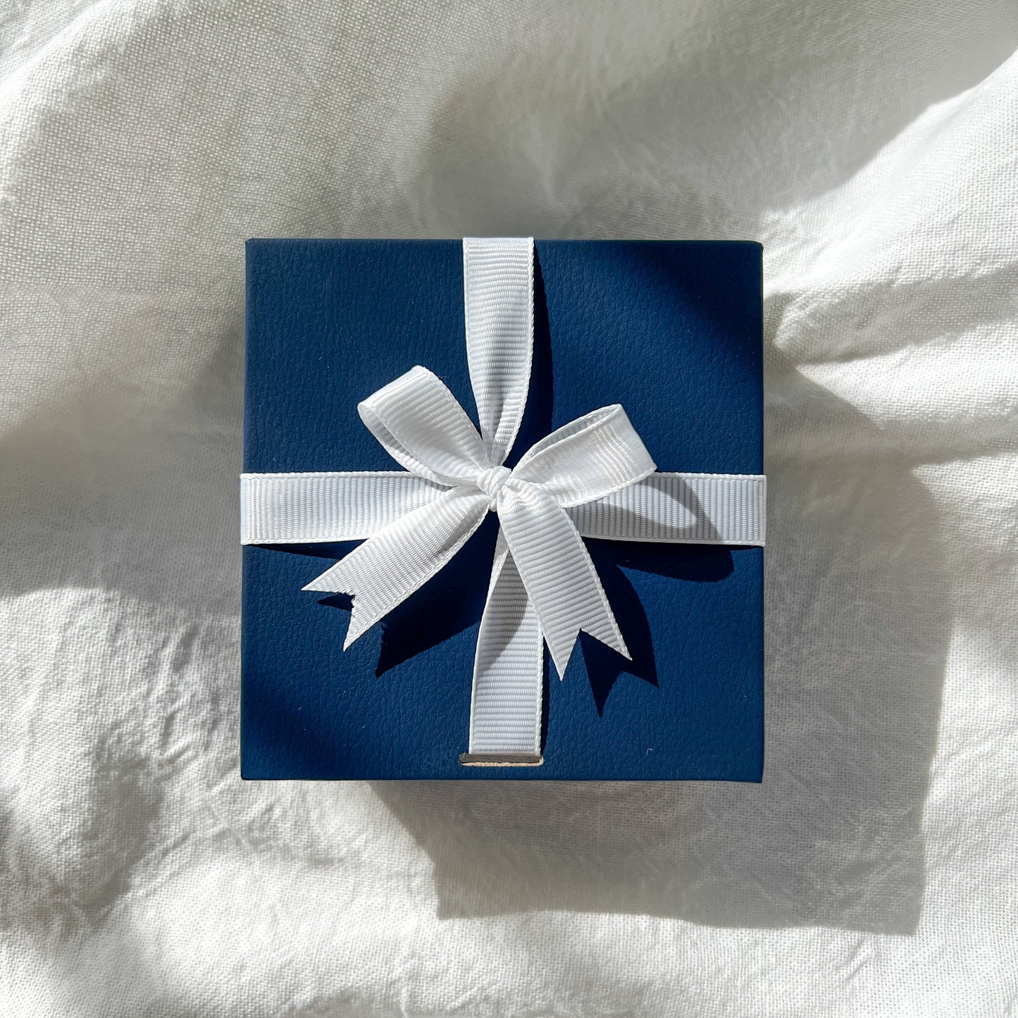 navy gift box with white ribbon