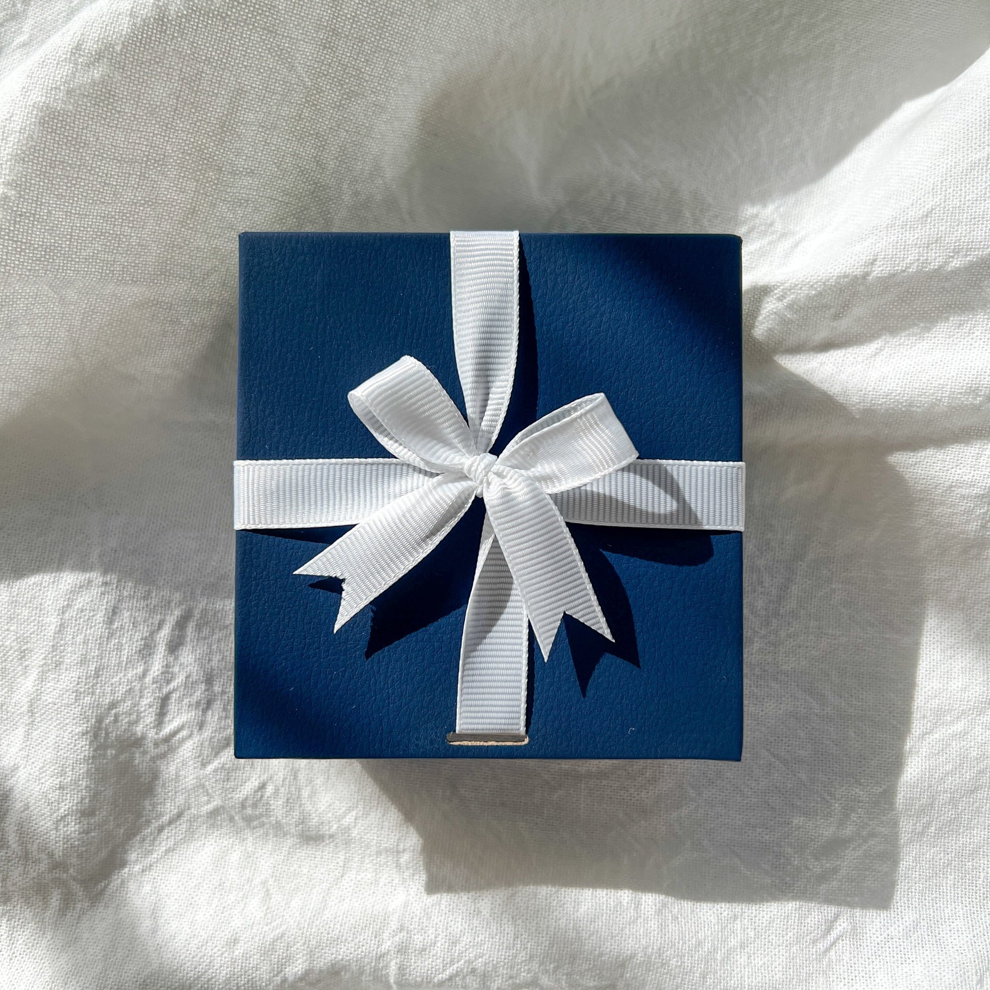 navy gift box with white ribbon